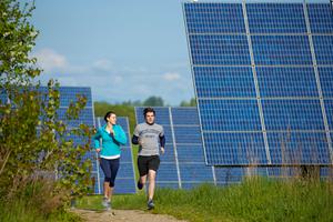 Students jog on running trails that wind through solar panels on the outskirts of Middlebury College in Vermont.