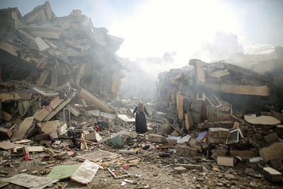 A woman stands amid rubble in al-Zahra after an Israeli airstrike on October 19, 2023.