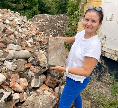 Anna Prokaeva gathers bricks from a pile of rubble.