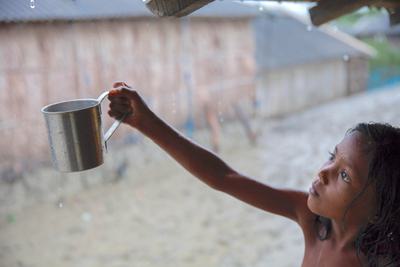 A girl collects rain, the main source of drinking water in Shyamnagar, Bangladesh, where waters are highly saline.