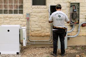 A technician installs a Base Power home battery system that will sell electricity to the power grid in Texas.