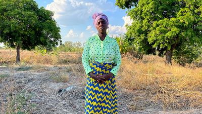 Ellen Sinoya stands on the remains of her home, eight months after it was destroyed by Cyclone Freddy.