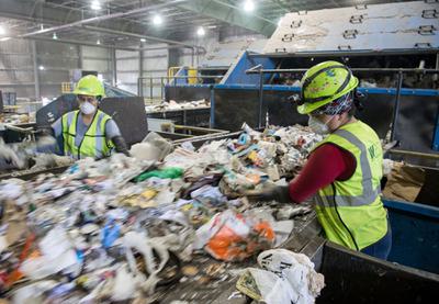 Workers sort recycling material at a waste management facility in Elkridge, Maryland.