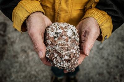 Geologist Greg Barnes holds a rock containing crystals at a rare earth mining site near Narsarsuaq, Greenland.