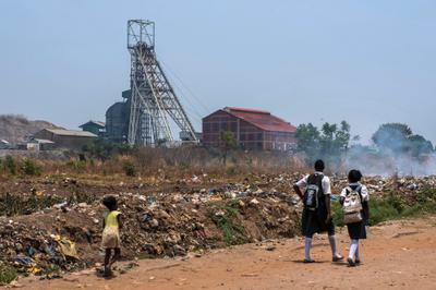 Children walk past the Mopani copper mine in Kitwe.