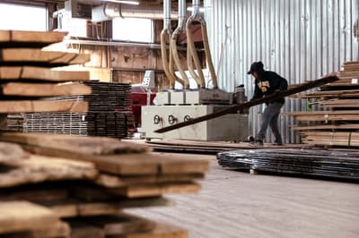 A worker refinishes reclaimed wooden siding at a sawmill in Pine Plains, New York.