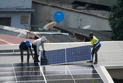 Workers install solar panels on a home in Lagos, Nigeria.