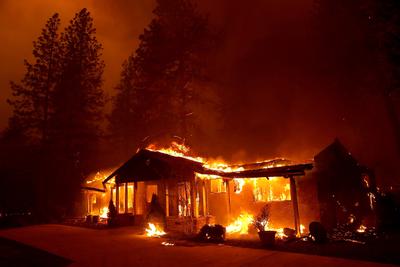 A home burns in the 2018 Camp Fire in Paradise, California. When houses burn, plastic pipes and other human-made materials pollute the water system.