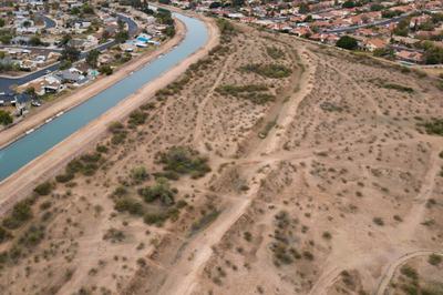 The remnants of canals used by the Hohokam people for centuries can still be seen in the sandy soil here in Mesa, Arizona, with the ancient canal path running parallel to the modern-day South Canal, which carries water from the Salt River.