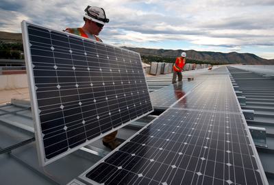 Workers install solar panels as part of a U.S. Department of Energy/Xcel project in Colorado.
