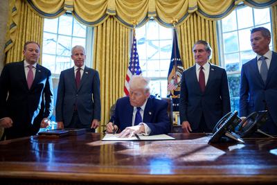 President Trump signs an executive order flanked by members of his cabinet on February 14.