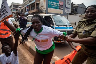 A Ugandan police officer arrests an activist protesting EACOP in Kampala in August 2024.