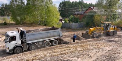 Workers gravel a road with recycled debris in the village of Zdvyzhivka.